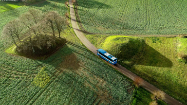Skolbuss kör på en enslig väg på landsbygden.