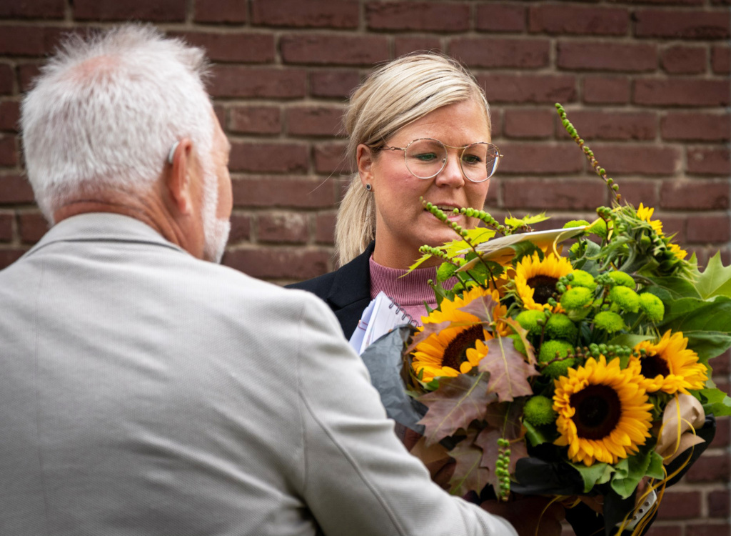 Bildningsnämndens ordförande Lars Mikkelä (M) överlämnar en bukett solrosor till rektor Anna Malmquist.
