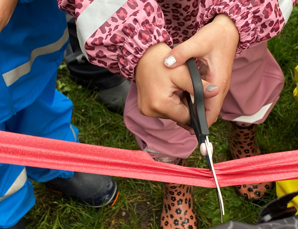 Barn klipper rött band vid invigningen av Högalids förskola.