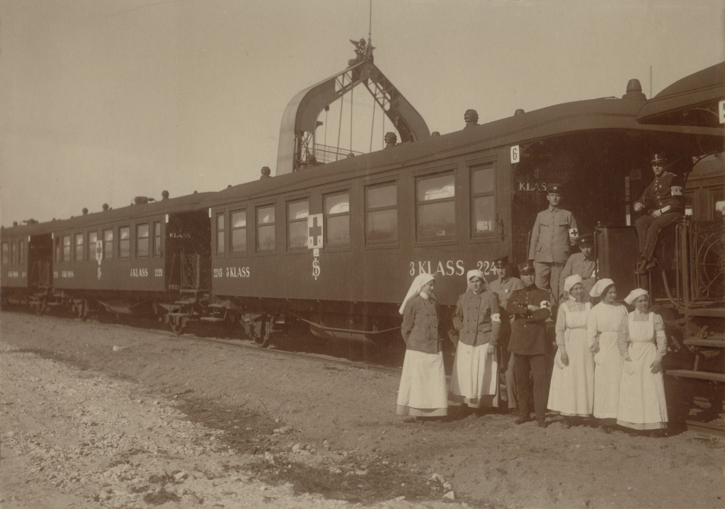 Svartvitt fotografi visar rödakorspersonal framför tåg