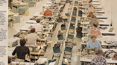 Fabriksarbetare vid skrivbord i stor sal