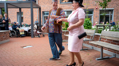 Man och kvinna dansar och visar upp kläder från 1960-talet.